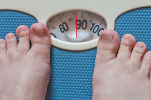 GLP-1 and eating disorder history represented by a person standing on a bathroom scale.